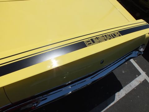 Close-up of a yellow car's deck lid with ELIMINATOR stripe graphic