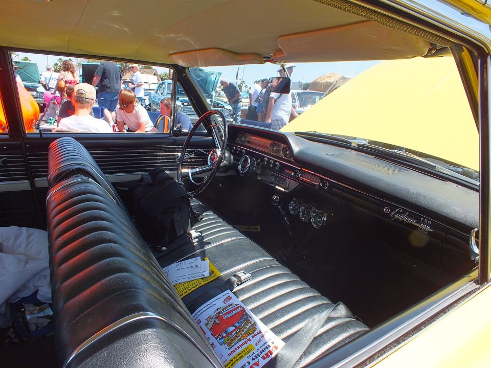 Interior of a yellow car with black ribbed bench seat and dash