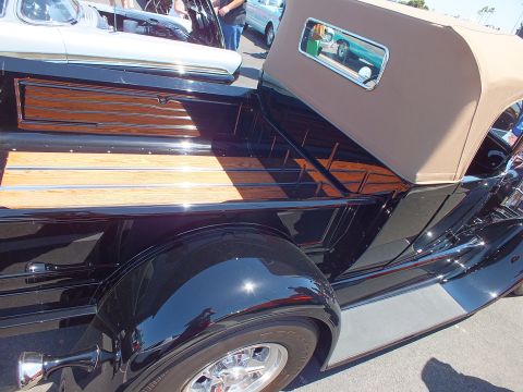 Black vintage woody-style vehicle with wood paneling and tan top