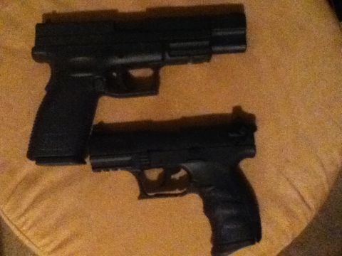 2006 Ford E350 - A close-up view of two black handguns resting on a textured surface.
