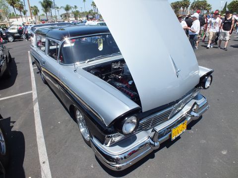 Silver and black 1950s station wagon with open hood and yellow plate