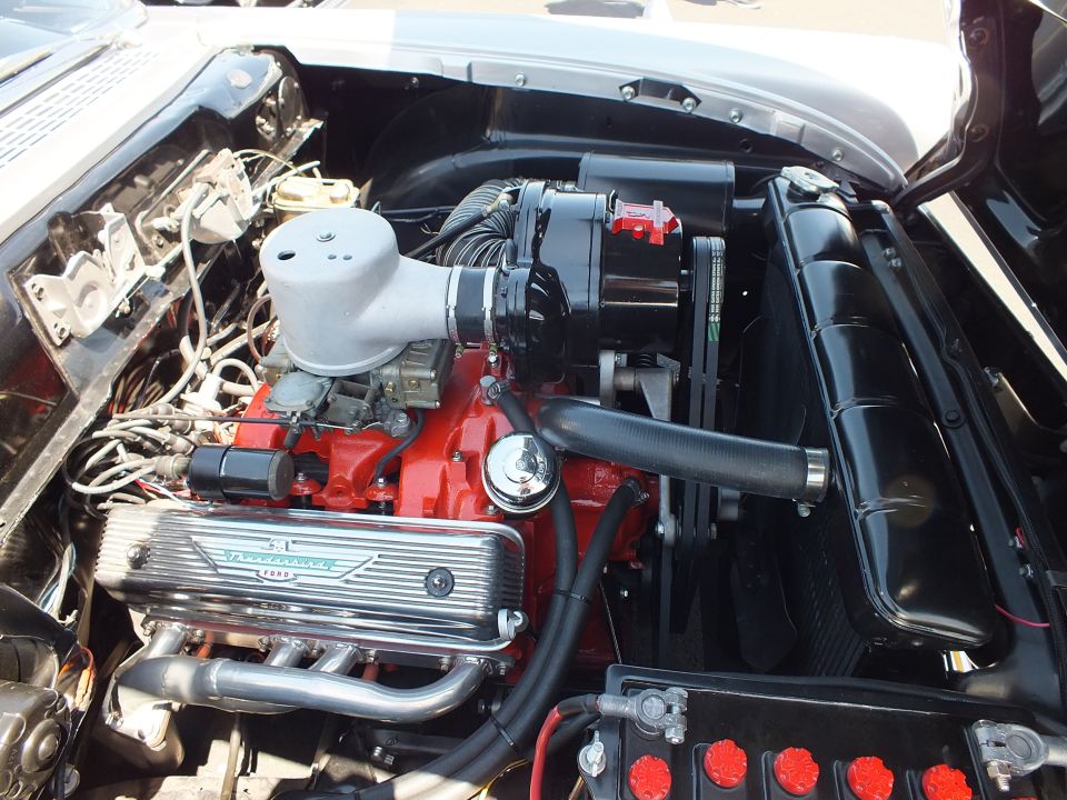 Vintage V8 engine bay with red block and Thunderbird valve covers