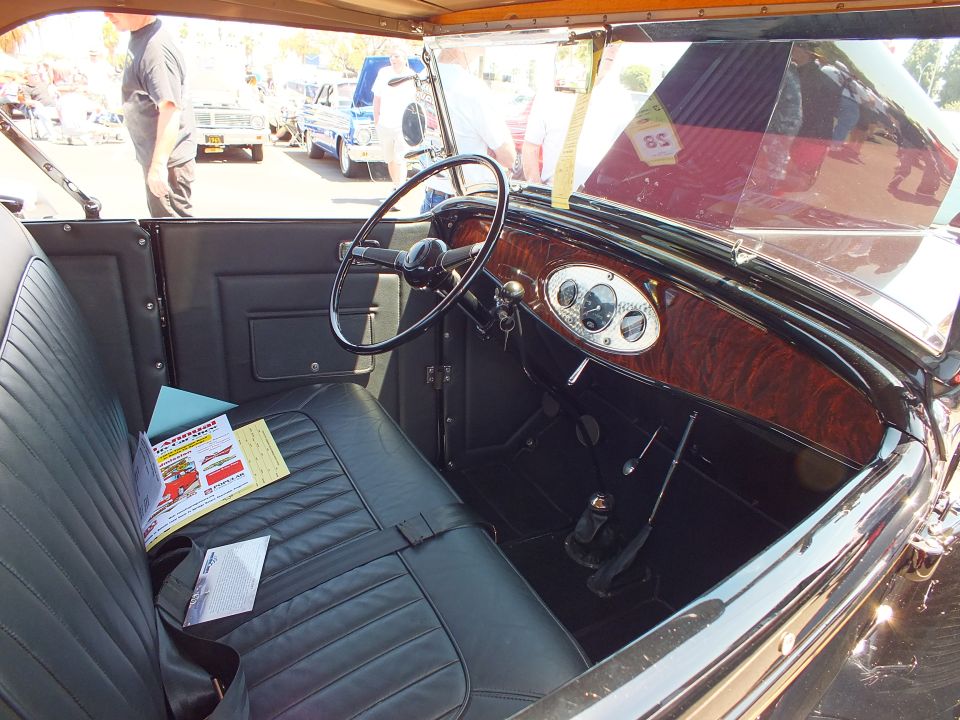 Vintage open car interior with woodgrain dash and black bench seat