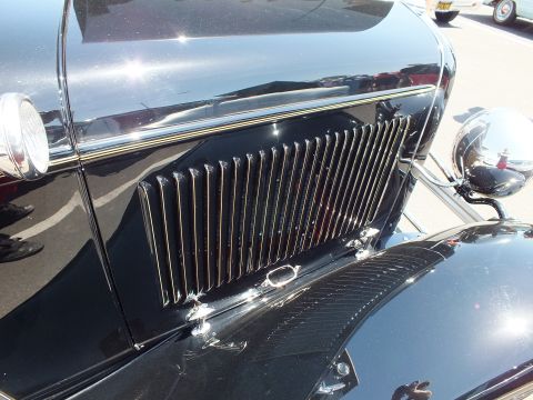 Close-up of a vertical-louver grille and chrome trim on a black car