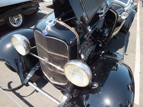 Front view of a black Ford hot rod with chrome grille and headlights