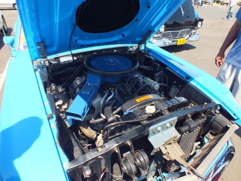 Engine bay of a blue car with blue valve covers and round air cleaner