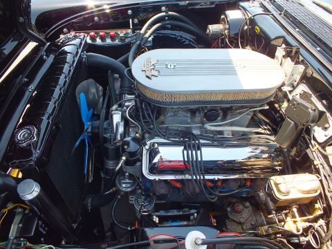 Chromed V8 engine with finned oval air cleaner in a black engine bay