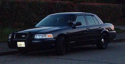 2001 Ford Crown Victoria - A black 2001 Ford Crown Victoria is seen from a three-quarter front view, parked on the side of the road.