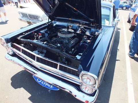 Dark blue Ford coupe-utility with raised hood and Ford-badged grille