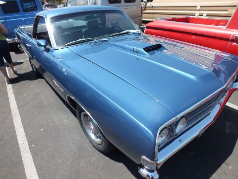 Light blue Ford Ranchero coupe-utility with hood scoop at a car show