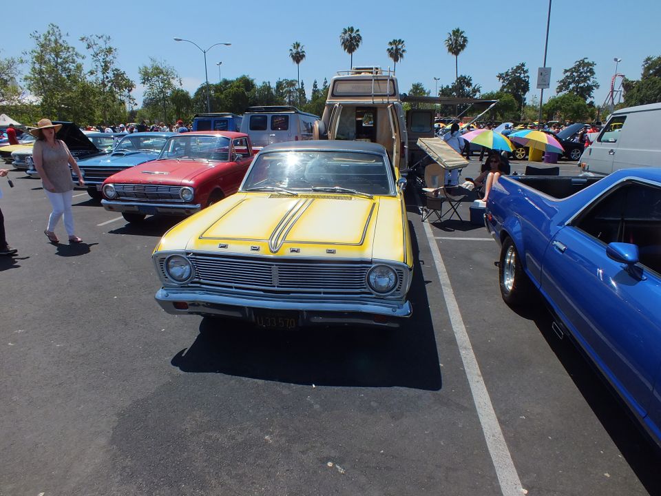 Yellow Ford Falcon coupe-utility front with twin hood stripes at a car show