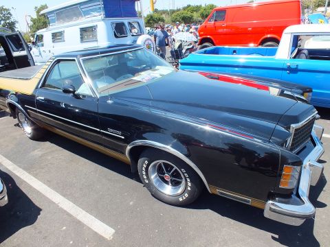 Black coupe-utility car-pickup with chrome trim and Cooper-tire mag wheels at a car show