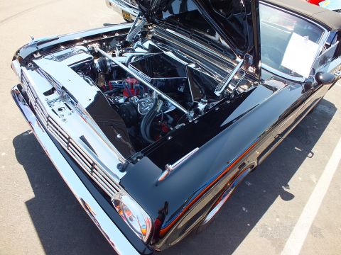 Open hood and detailed engine bay of a black custom 1960s Ford