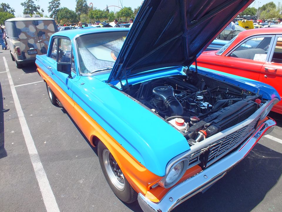 Blue-and-orange 1960s Ford Falcon with open hood, front three-quarter at a car show