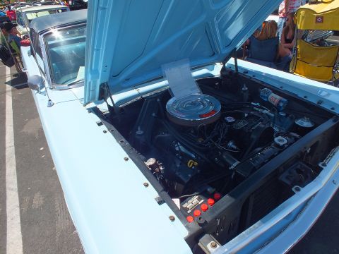 Engine bay of a light-blue Ford convertible showing air cleaner and radiator