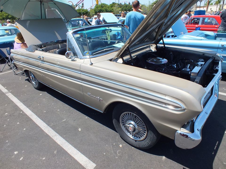 Gold-tan classic convertible with hood open at a car show