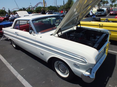 White classic two-door hardtop with red interior and hood open