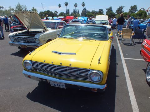 Yellow Ford convertible with FORD-lettered grille at a car show