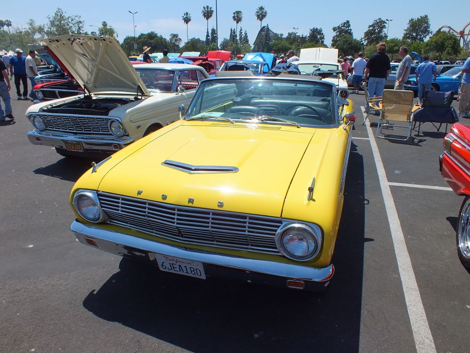 Yellow Ford convertible with FORD-lettered grille at a car show