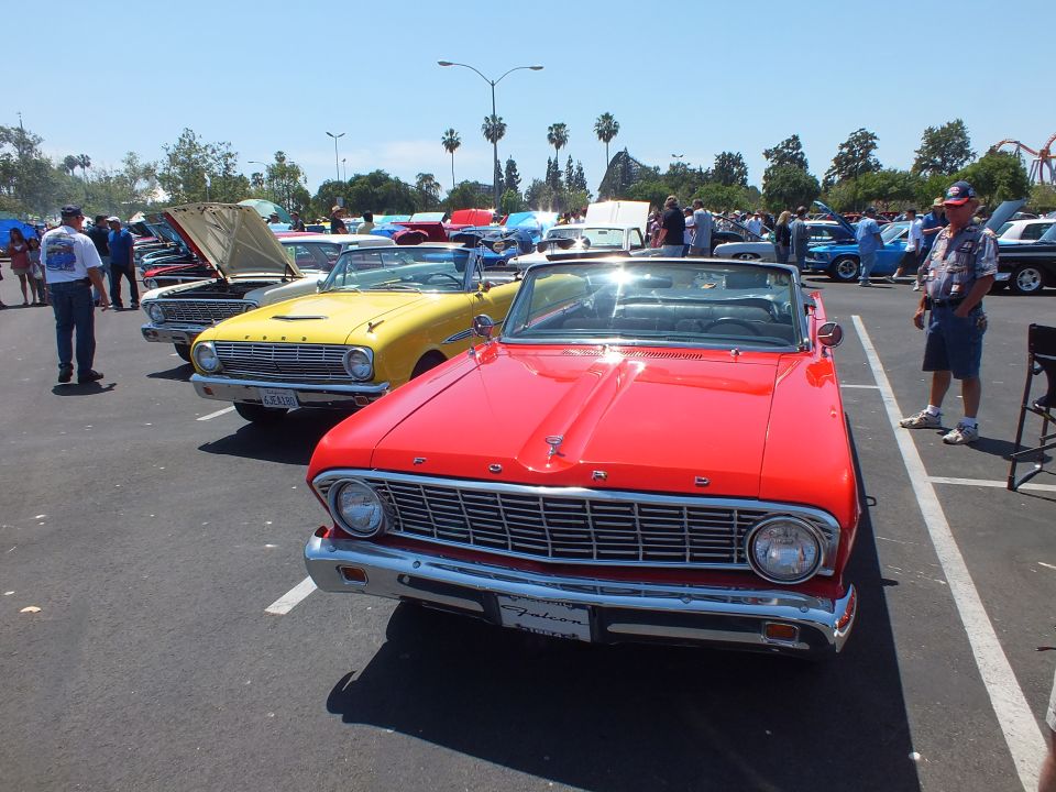 Red Ford convertible with FORD-lettered grille beside a yellow car