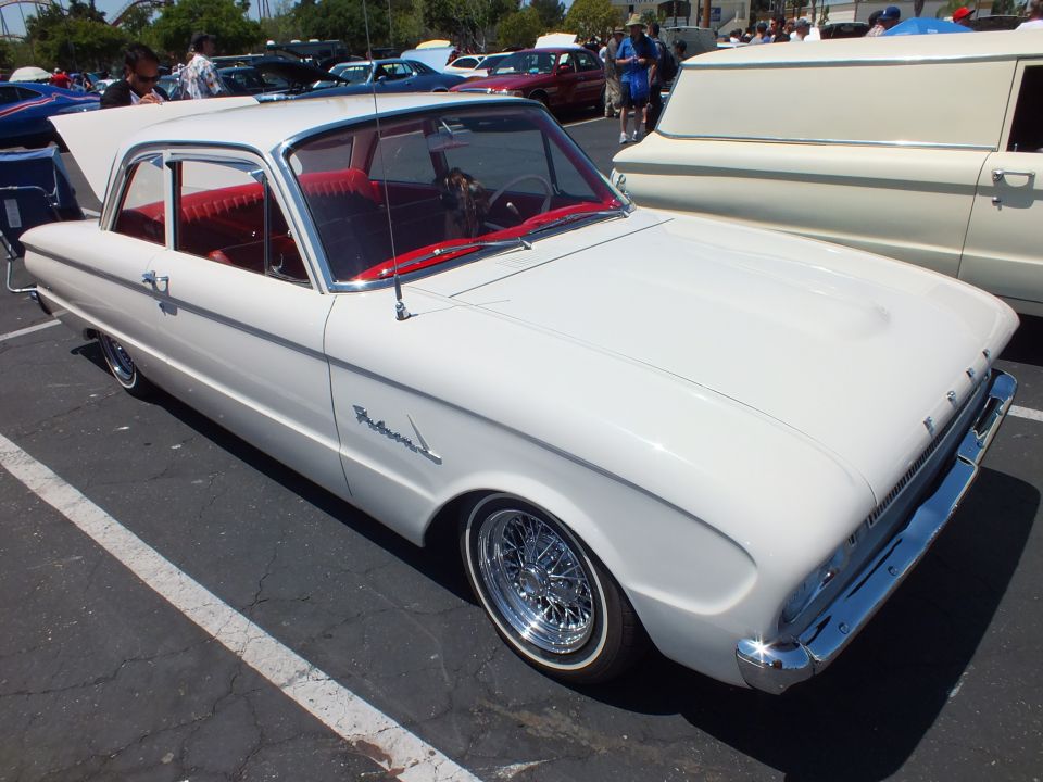 White classic two-door sedan with red interior and wire wheels