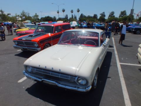 White classic Ford two-door with FORD-lettered grille at a car show