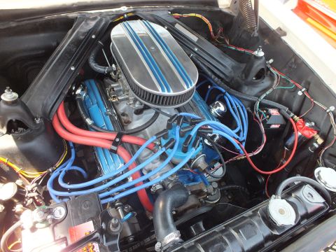 Open engine bay with chromed valve covers, blue spark plug wires and finned air cleaner