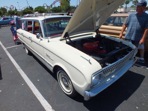 White early-1960s station wagon with hood open showing red air cleaner