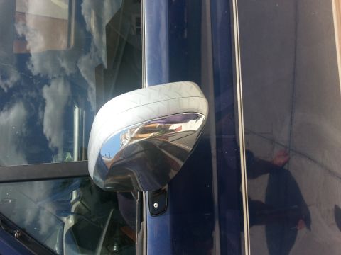 1994 Ford Bronco - A close-up view of a vehicle's side mirror and door panel, showing reflective surfaces and decorative pinstripes.