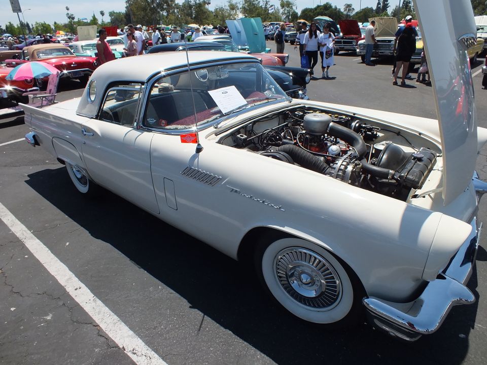 White mid-1950s two-seat hardtop with porthole window and hood open