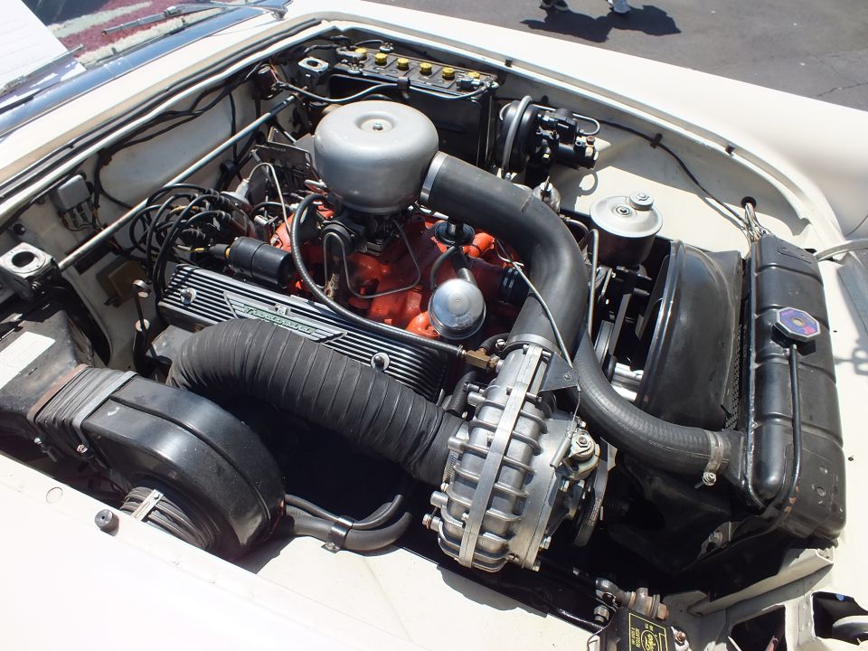 Engine bay close-up with finned valve covers, orange block and round air cleaner