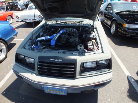 Front of gray primered coupe with open hood and California plate 1PEU641