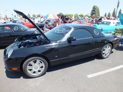 Black hardtop convertible side view with hood open at car show