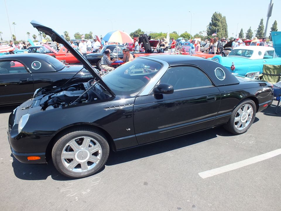 Black hardtop convertible side view with hood open at car show