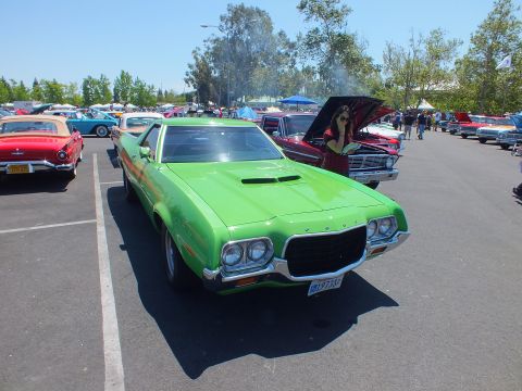 Bright green classic muscle car front view with hood scoop at car show