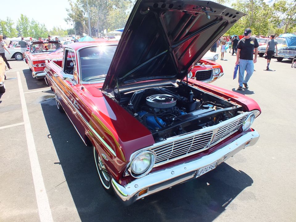 Dark red classic car-based pickup with open hood showing V8 engine