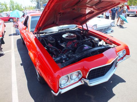Red classic muscle car with open hood showing chrome air cleaner