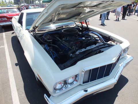 White car-based pickup with open hood and blue plug wires on V8