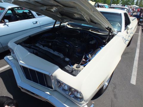 White car-based pickup with open hood, blue wires and fender pinstriping