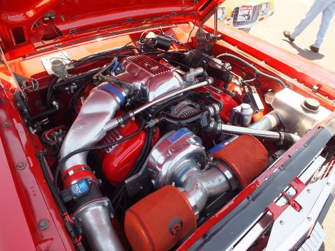 Engine bay with polished centrifugal supercharger and red air filters