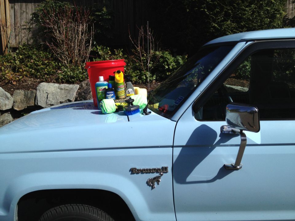 1985 Ford Bronco II fender with car wash bucket, soap, and sponges on hood