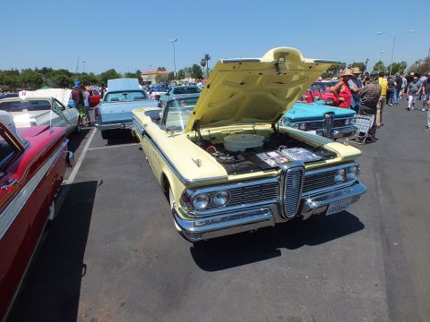 Yellow Edsel convertible with open hood at an outdoor car show