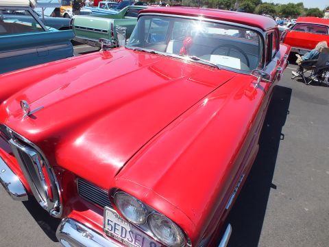 Red Edsel hardtop front with horse-collar grille and license plate at a car show