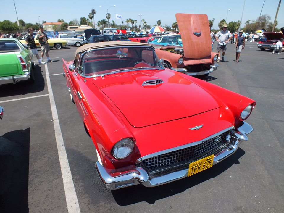 Red Ford Thunderbird convertible with tan top at a car show