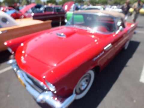 Red Ford Thunderbird with tan top and red interior at a car show