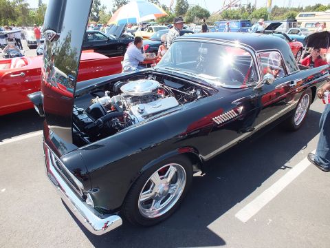 Black Ford Thunderbird hardtop with hood and door open at car show
