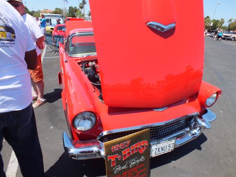 Red 1957 Ford Thunderbird front with hood up and 1957 T-Bird display sign
