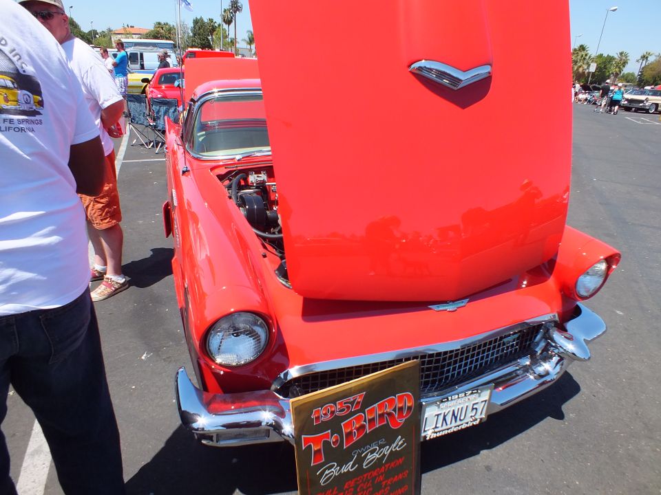 Red 1957 Ford Thunderbird front with hood up and 1957 T-Bird display sign