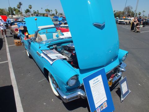 Light blue Ford Thunderbird with hood up and display sign at car show