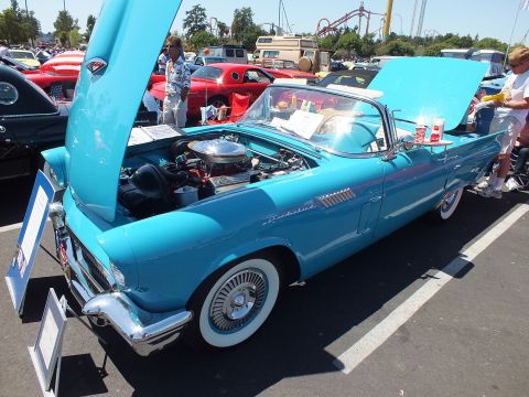 Turquoise Ford Thunderbird convertible with hood up and whitewall tires